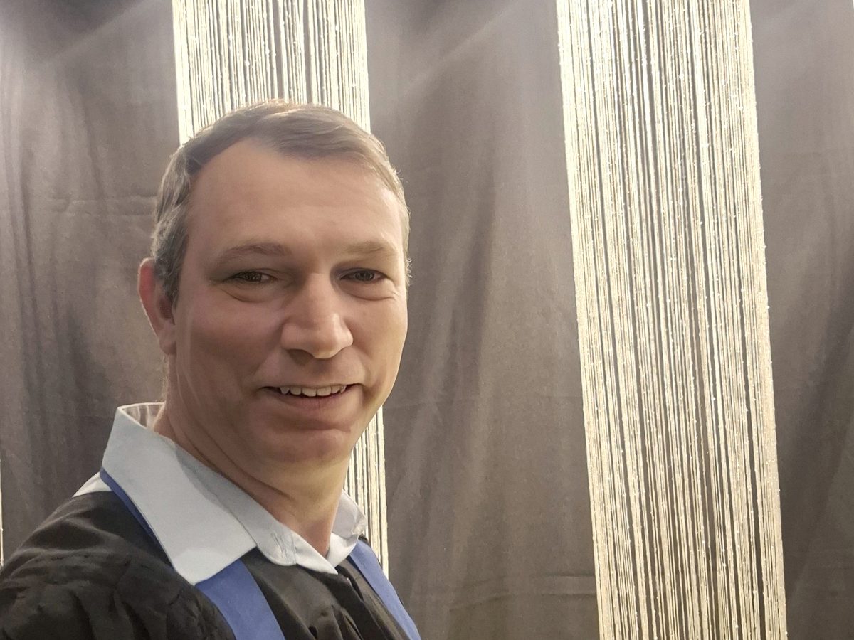 Wagner Castilho sorrindo no dia da formatura em Psicologia